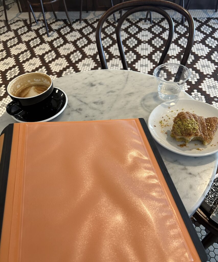 photo of binder on table with coffee and croissant